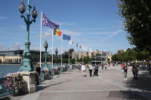 塞納河畔埃皮奈的住宿－"Olympic Sweet Home" Paris Stade de France，一群人沿着人行道走着,挂着旗帜