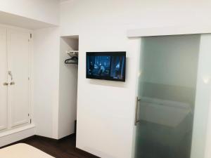 um quarto com uma porta com uma televisão na parede em Cero estrellas Cabildo em Sanlúcar de Barrameda