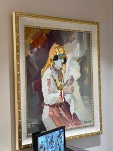 a framed painting of a woman sitting on a chair at SOL INVICTUS Boutique Hotel Durres Albania in Durrës +46 photos