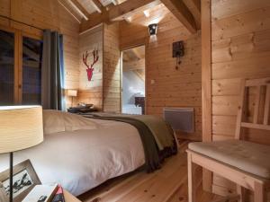 ein Schlafzimmer in einem Blockhaus mit einem Bett und einem Schreibtisch in der Unterkunft Chalet cosy à Courchevel La Tania - Idéal pour familles et amis, ski aux pieds ! - FR-1-575-31 in Courchevel + 9 Fotos