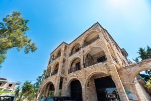 スパタにあるStone Palace Hotel Free Shuttle From and to Athen's Airportの青空を背景にした古いレンガ造りの建物