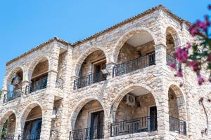 a stone building with balconies on the side of it at Stone Palace Hotel Free Shuttle From and to Athen's Airport in Spáta