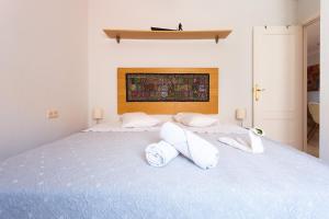 Un dormitorio con una cama azul con toallas. en Piso Velero Cerca a la Playa Sanlucar de Barrameda, en Sanlúcar de Barrameda