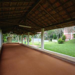 a large pavilion with a red floor in a park at HOTEL FAZENDA ROCHEDO in Conservatória