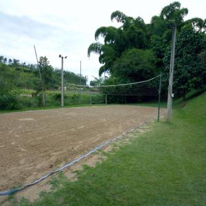 a volleyball court with a net in a field at HOTEL FAZENDA ROCHEDO in Conservatória