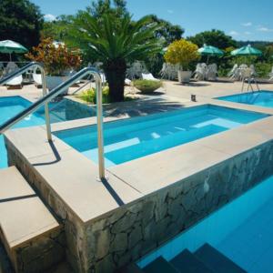 a swimming pool with a stairway leading to a swimming pool at HOTEL FAZENDA ROCHEDO in Conservatória