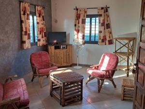 a living room with chairs and a tv at Le Kenkeni in Ouoran