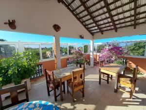 un patio con mesas y sillas en el balcón en Le Kenkeni, en Ouoran