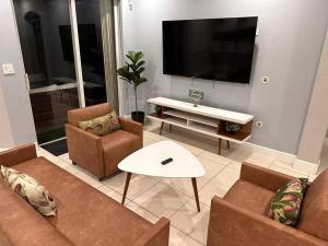 a living room with a couch and chairs and a tv at Comfortable New Home Miami in Tamiami