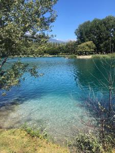 un grand lac avec de l'eau et des arbres bleu clair dans l'établissement Le Preyet, à Veysonnaz
