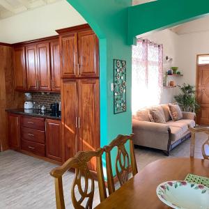 eine Küche und ein Wohnzimmer mit einem Tisch und einem Sofa in der Unterkunft Travellers Villa in Roseau
