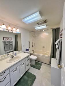 a bathroom with a sink and a toilet and a tub at The State Room - Cliffside, Ocean Views in Kodiak