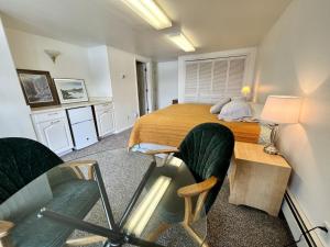 a small bedroom with a bed and two chairs at The State Room - Cliffside, Ocean Views in Kodiak