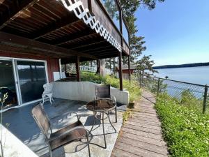 een patio met stoelen en een tafel en uitzicht op het water bij The State Room - Cliffside, Ocean Views in Kodiak