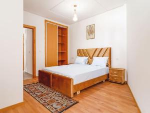 a bedroom with a bed with a wooden headboard at Magnifique Appartement Golf Tanger for Families in Tangier