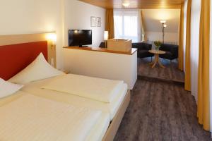 una camera d'albergo con letto e soggiorno di Hotel Hirschen a Glottertal