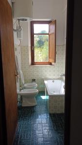 een badkamer met 2 toiletten, een bad en een wastafel bij La dimora delle terme di Segesta in Castellammare del Golfo