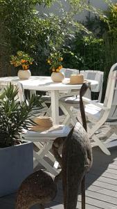 a white table with chairs and a table with food on it at Chez Lily in Vélizy-Villacoublay