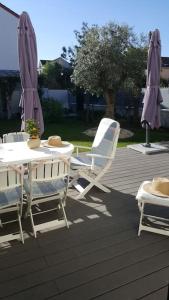 a patio with a table and chairs and umbrellas at Chez Lily in Vélizy-Villacoublay