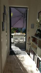 an open hallway with a table with a purple umbrella at Chez Lily in Vélizy-Villacoublay +28 photos