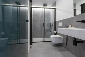 La salle de bains est pourvue de toilettes, d'un lavabo et d'une douche. dans l'établissement cavaedium guest house, à Arona