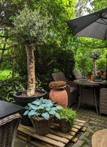 een patio met een tafel en stoelen en een boom bij Landhaus Spanier in Nonnweiler