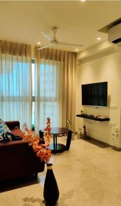 ムンバイにあるTrendy1BR+smart kitchen +Living room+1.5 toiletsのリビングルーム(ソファ、テーブル、テレビ付)