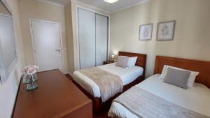 フンシャルにあるVilla Strelitziaのベッド2台とテーブルが備わるホテルルームです。