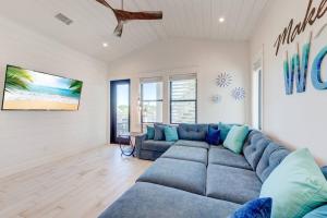 a living room with a blue couch and a tv at New Luxury Villa and Private Pool-Cart-Ocean View! in Port Aransas