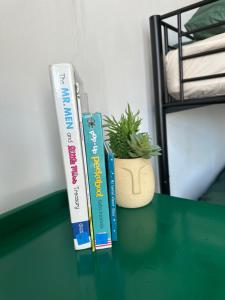 dois livros sentados numa mesa com um vaso de plantas em Emerald Apartment Pleasure Beach Blackpool em Blackpool