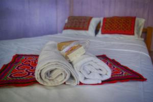 TamboにあるNiwe Mai plant medicine retreatのベッドの上に座るタオルの山