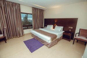 Habitación de hotel con cama y ventana en Noble House Hotel en Kumasi