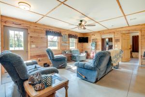 uma sala de estar com paredes de madeira e cadeiras azuis em Toivola Home with Fire Pit 8 Mi to Lake Superior! em Toivola