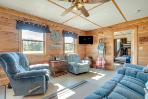 uma sala de estar com mobiliário azul e uma ventoinha de tecto em Toivola Home with Fire Pit 8 Mi to Lake Superior! em Toivola