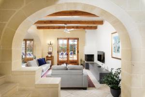 an archway in a living room with a couch at Dar ta' Lonza Villa with Private Pool in Għasri