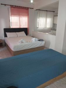 a bedroom with a large bed with a blue blanket at PELEKAN rooms and apartments athina 11 in Pefkohori