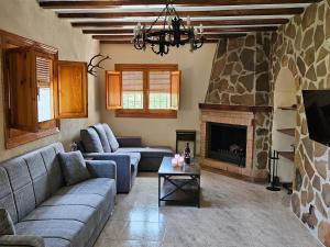 Una sala de estar con un sofá y una chimenea. en Cortijo Los Portillos, en Arbuniel