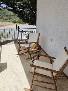 2 sillas y una mesa con un plato de fruta en el porche en Cortijo Los Portillos, en Arbuniel