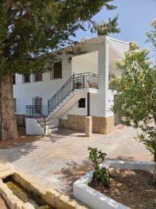 un edificio blanco con una escalera delante en Cortijo Los Portillos, en Arbuniel