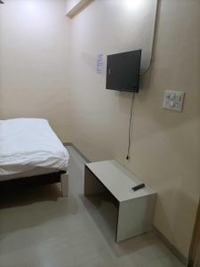 a room with a bed and a table and a tv at OYO IAE566 Neelkanth Hotel in Rewāri