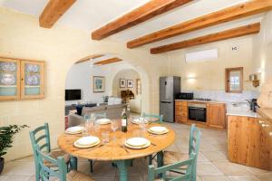 cocina y comedor con mesa de madera y sillas en Dar ta' Lonza Villa with Private Pool en Għasri