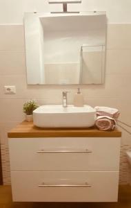 W łazience znajduje się biała umywalka i lustro. w obiekcie Matteo's House w mieście Penne