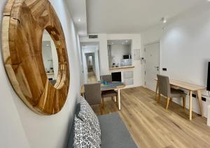 a living room with a dining room table and a mirror at NEW CAPUCHINOS Apartment 1 in Málaga