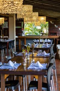 uma sala de jantar com mesas e cadeiras com guardanapos em Hotel Villaggio Tudo Bom em Uruau