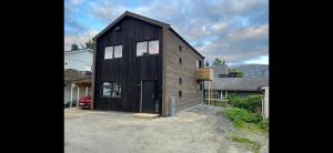 a wooden house with a garage in a yard at Tromsø central guest house with parking in Tromsø