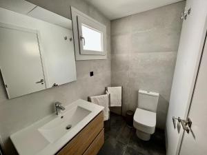 a bathroom with a sink and a toilet and a mirror at NEW CAPUCHINOS Apartment 1 in Málaga