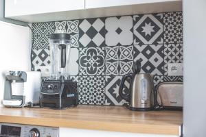 a kitchen counter with a blender and a tile wall at Colocation de luxe à Tourcoing avec jardin in Tourcoing