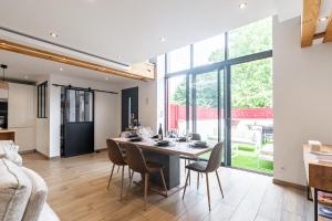 een eetkamer en een woonkamer met een tafel en stoelen bij Charmante Maison Climatisée avec son Jardin à 10 minutes de DIJON in Marsannay-la-Côte