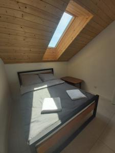 a large bed in a room with a skylight at Apartamenty Łagiewniki in Krakow