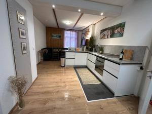 eine Küche mit weißen Schränken und einer Arbeitsplatte in der Unterkunft Gemütliches Doppelbett-Zimmer in Schöftland in Schöftland